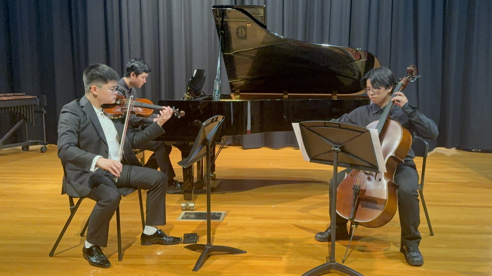 Vincent Huang performing with piano trio on stage