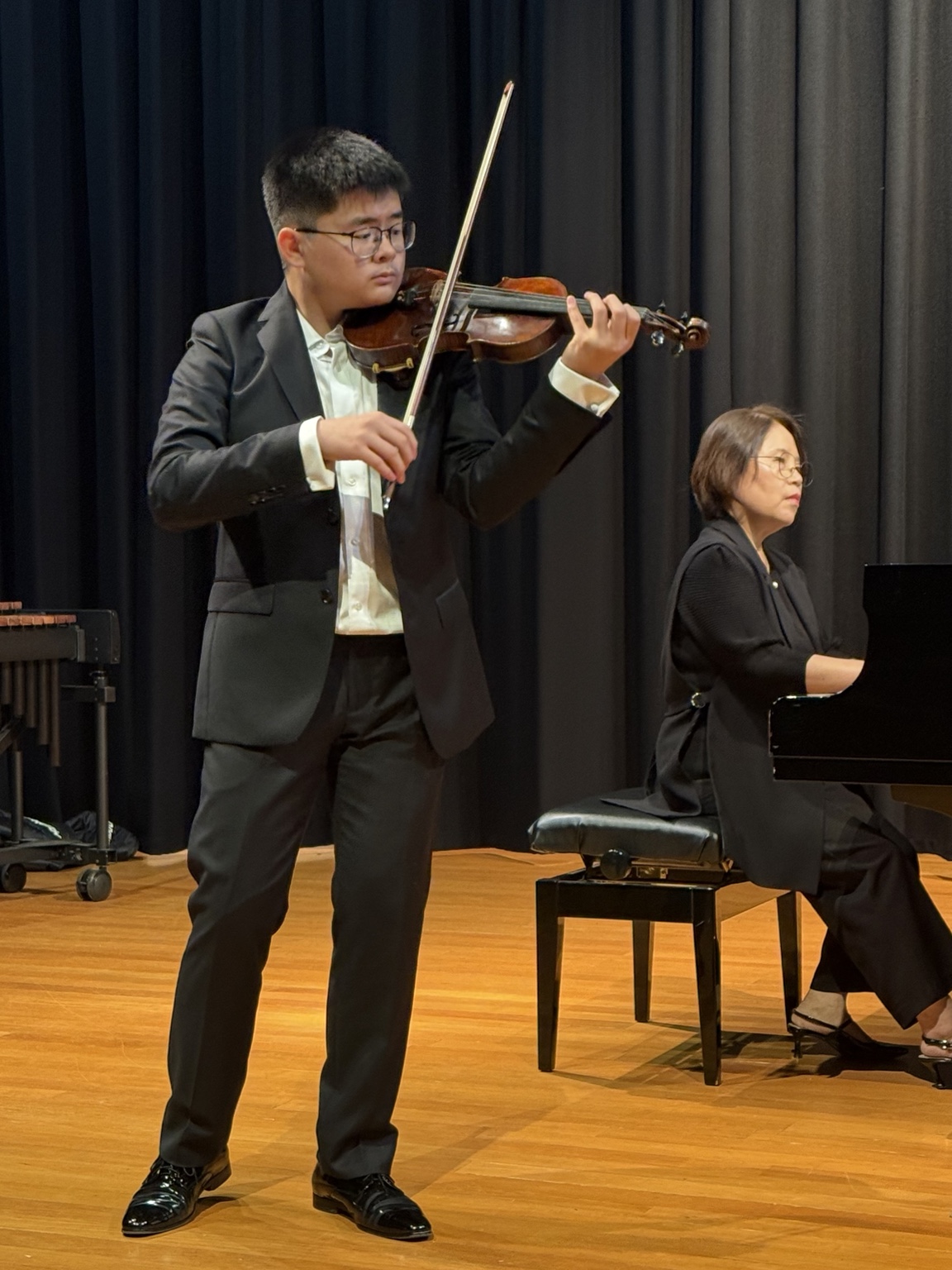 Vincent Huang performing on violin with a pianist